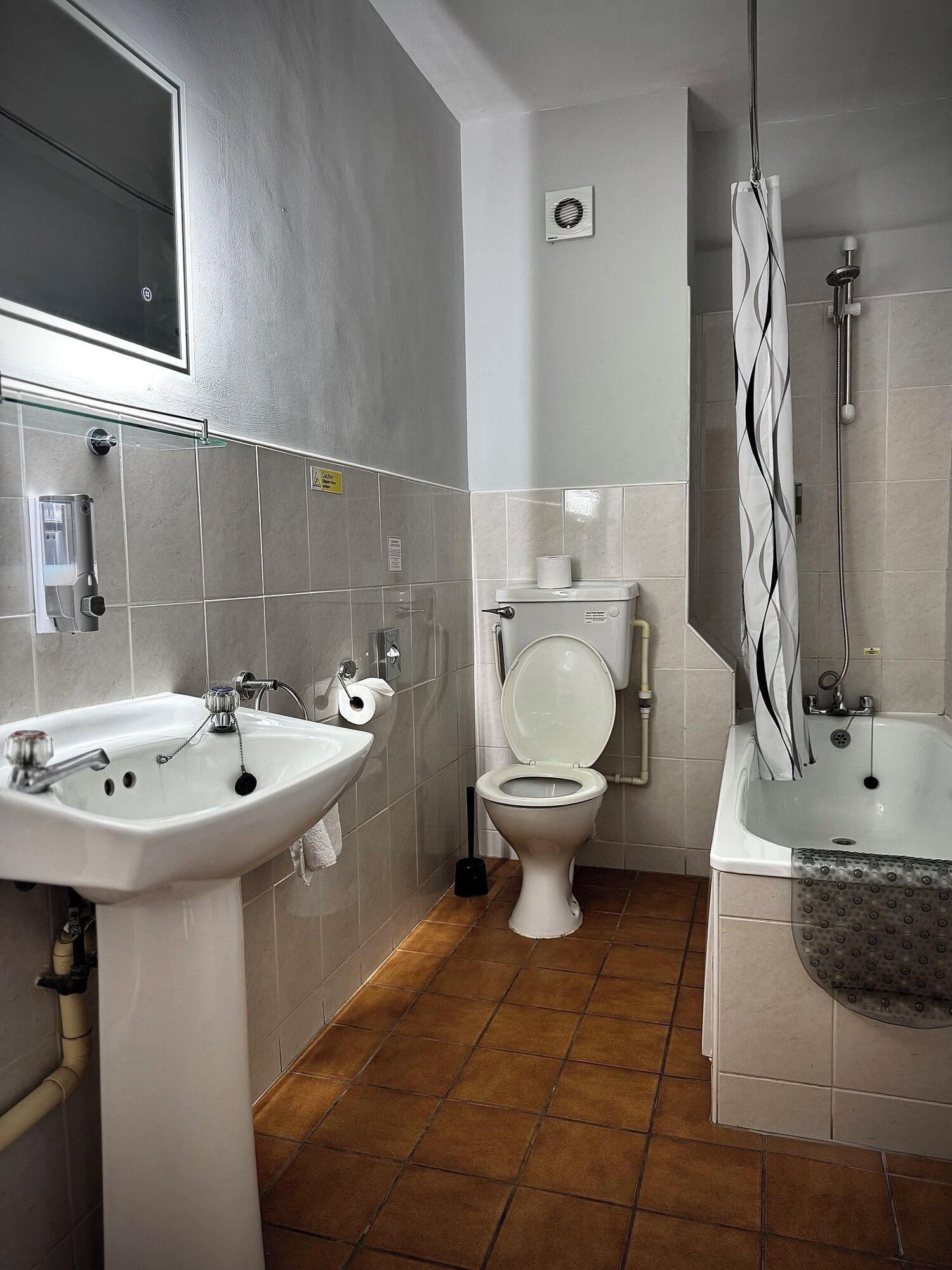 A bathroom with a sink, toilet, and bathtub.