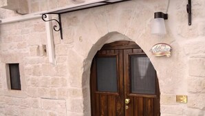 A stone building with a wooden door and a small window.