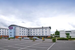 A hotel with a parking lot, a sign for 'Premier Inn,' and another sign for 'Inn on the Park.' - Premier Inn London Enfield (Enfield)