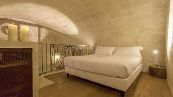 A bedroom with a bed, a nightstand, a dresser, and three candles.