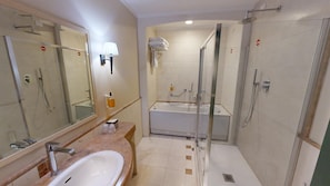 Un bagno moderno con lavandino, specchio, doccia e vasca da bagno.