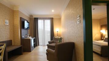 Ein Hotelzimmer mit einem Bett, einem Schreibtisch, einem Sessel, einem Fernseher und einer Lampe.