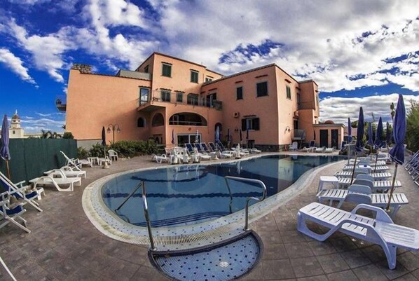 A swimming pool with lounge chairs and a building with balconies. - Hotel Terme Rosaleo (Casamicciola Terme)
