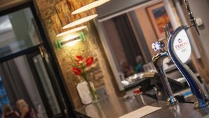 A hotel reception area with a counter, a beer tap, and a wall-mounted lamp. - The Trout (Cockermouth)