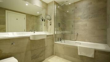 A modern bathroom with a glass-enclosed shower, a bathtub, and a toilet.