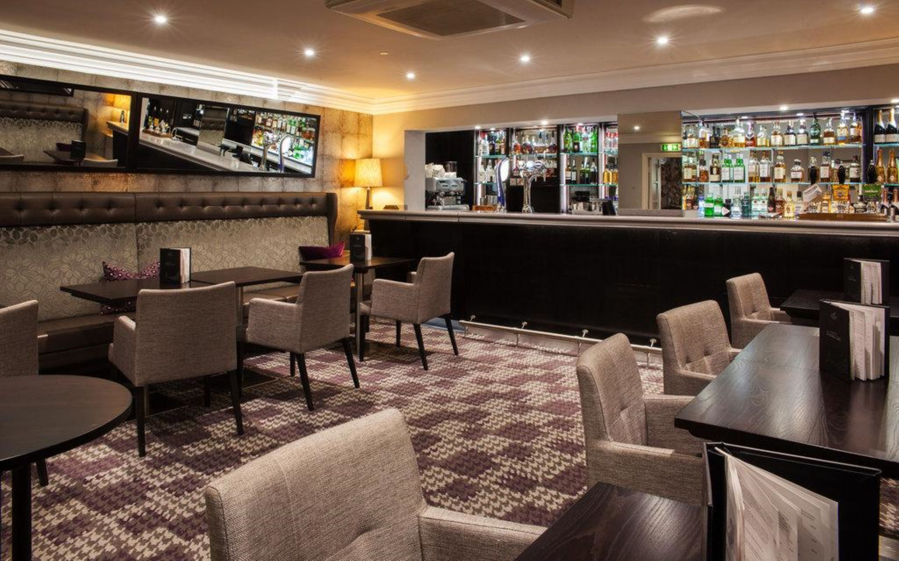 A bar area with seating and a television screen.