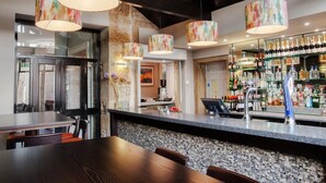 A bar area with a counter, bar stools, and a variety of bottles and glasses. - The Trout (Cockermouth)