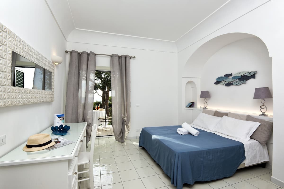 Una habitación de hotel moderna con cama, escritorio y vistas al exterior.