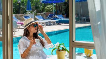 A poolside area with lounge chairs and umbrellas.