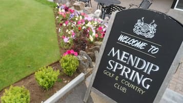 A sign welcoming to Mendip Spring Golf & Country Club with a logo above the text.