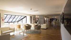 A modern hotel lobby with a high ceiling, large windows, and a mix of seating areas including sofas and chairs. - CIM Business Centre (Maidenhead)