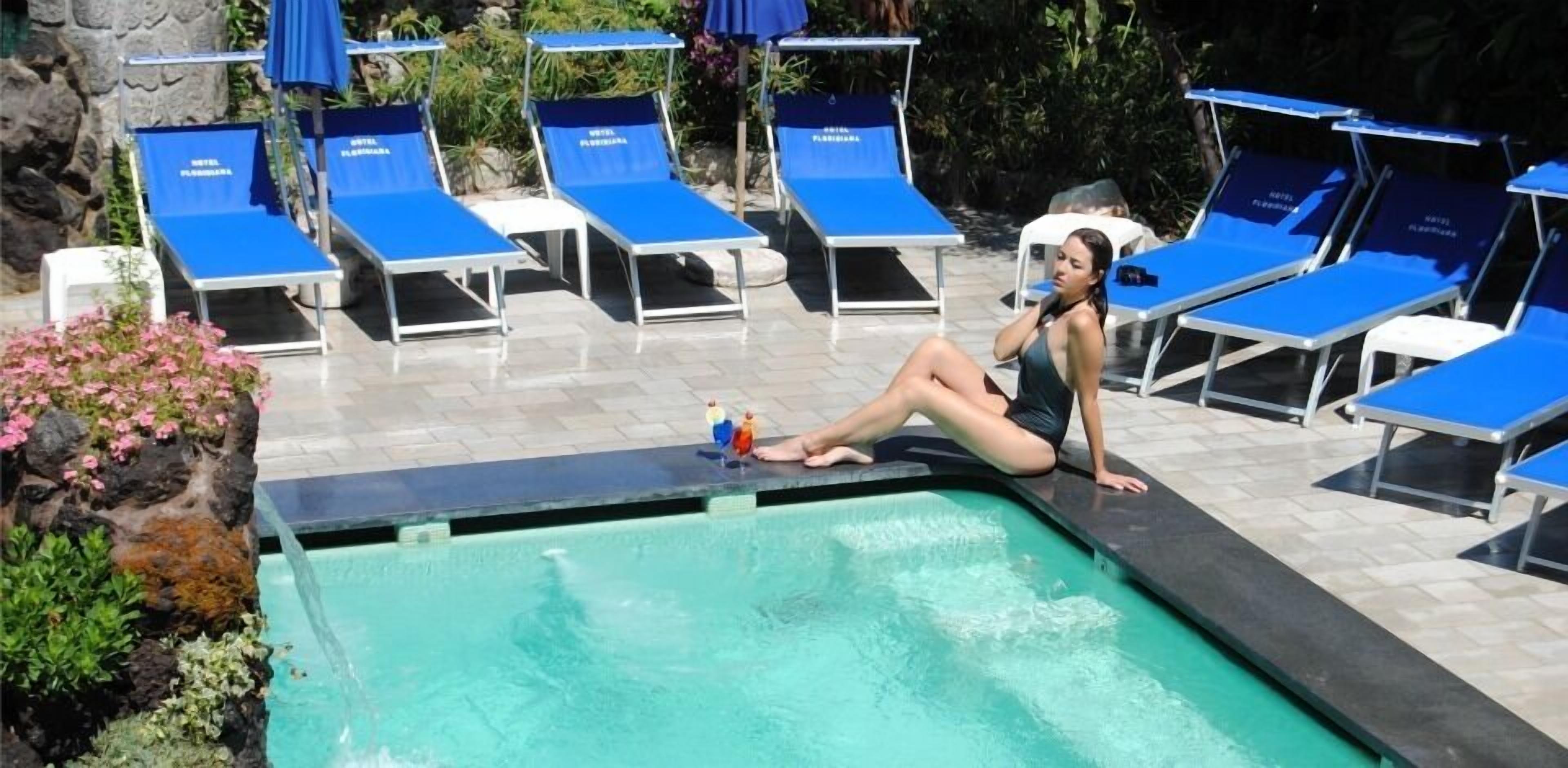 A poolside area with lounge chairs and a pool.