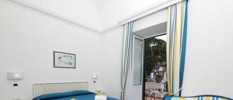 A hotel room with a bed, a sofa, a small table, and a chair.
