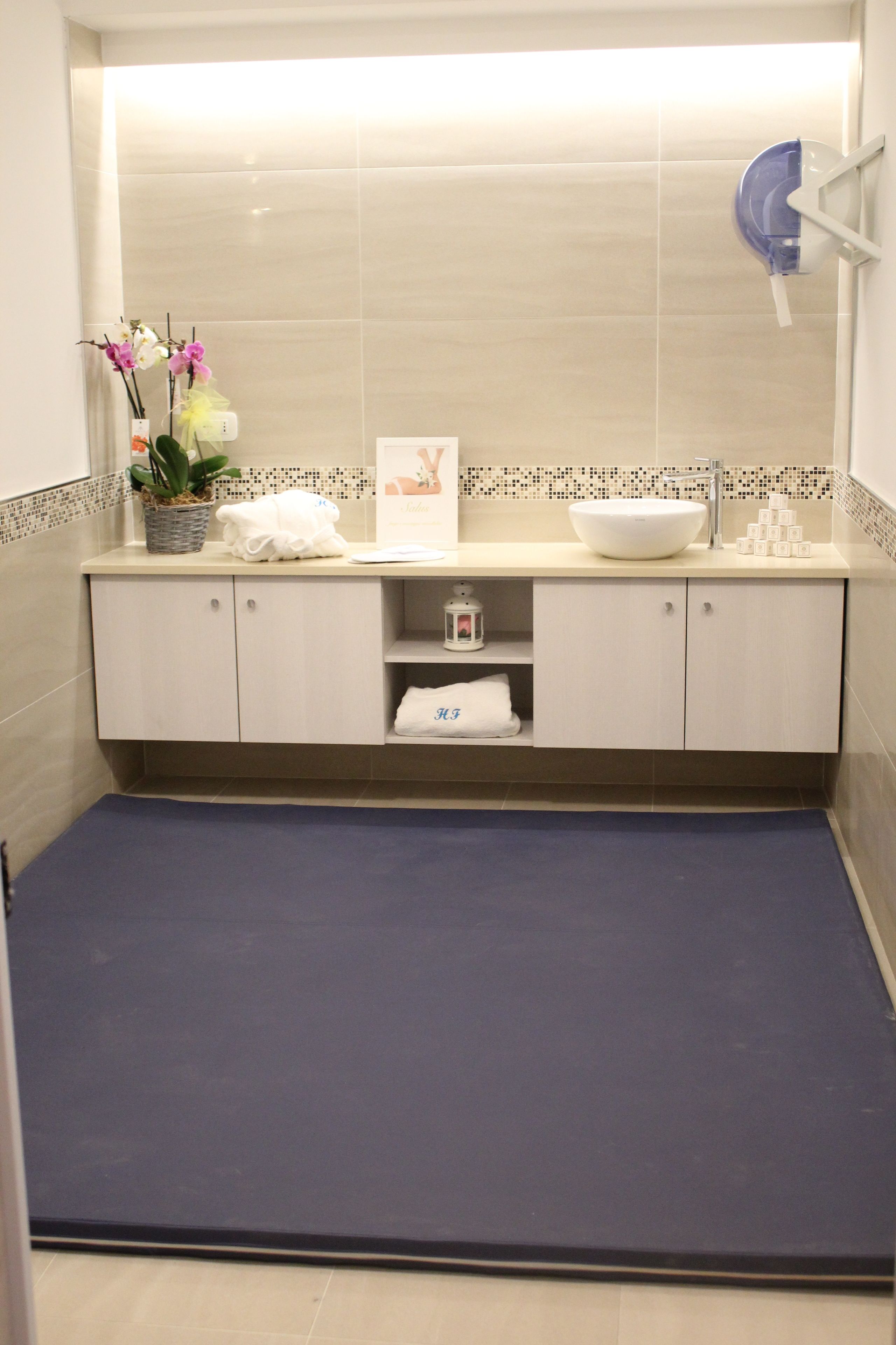 Un baño moderno con un lavamanos grande, un espejo y un perchero para toallas.