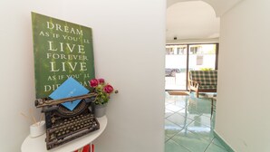 A hallway with a typewriter and a motivational poster on a shelf. - Maison Twentyfive (Ischia)