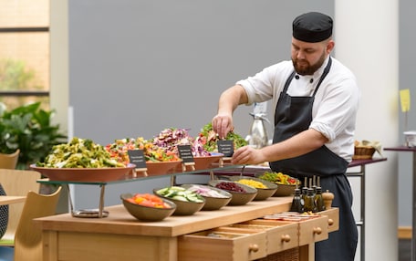 A buffet setup with various salads and food items.
