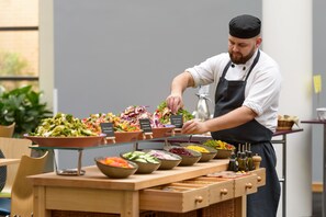 Montaje de bufé con ensaladas y diferentes opciones de comida.