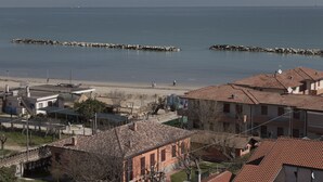 A coastal town with buildings, a beach, and a rocky breakwater. - Hotel Concorde (Bellaria-Igea Marina)