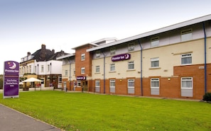 A hotel with multiple rooms, a signboard, and a well-maintained lawn. - Premier Inn Manchester - Heaton Park (Manchester)