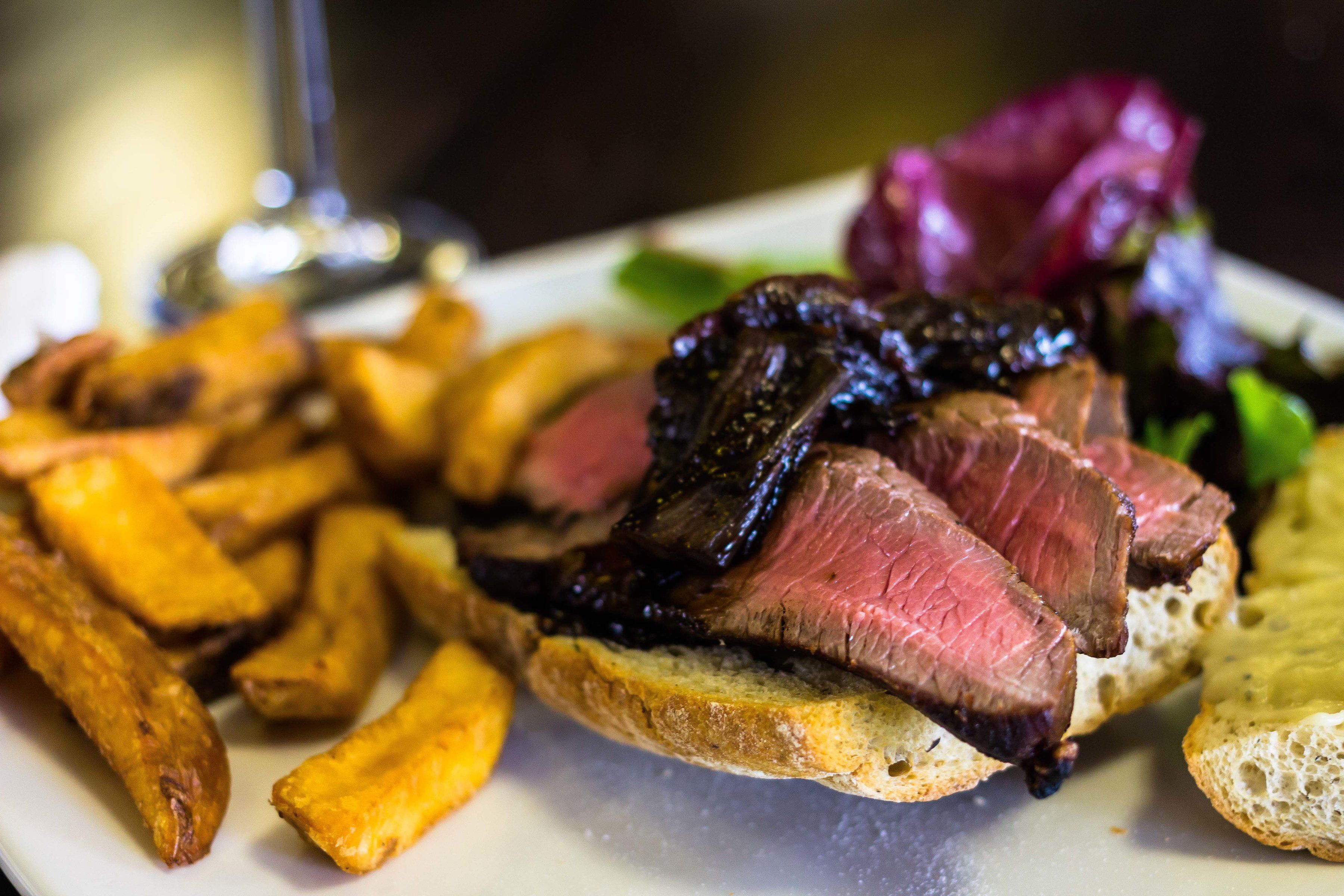 Un plato con carne, papas fritas y ensalada.