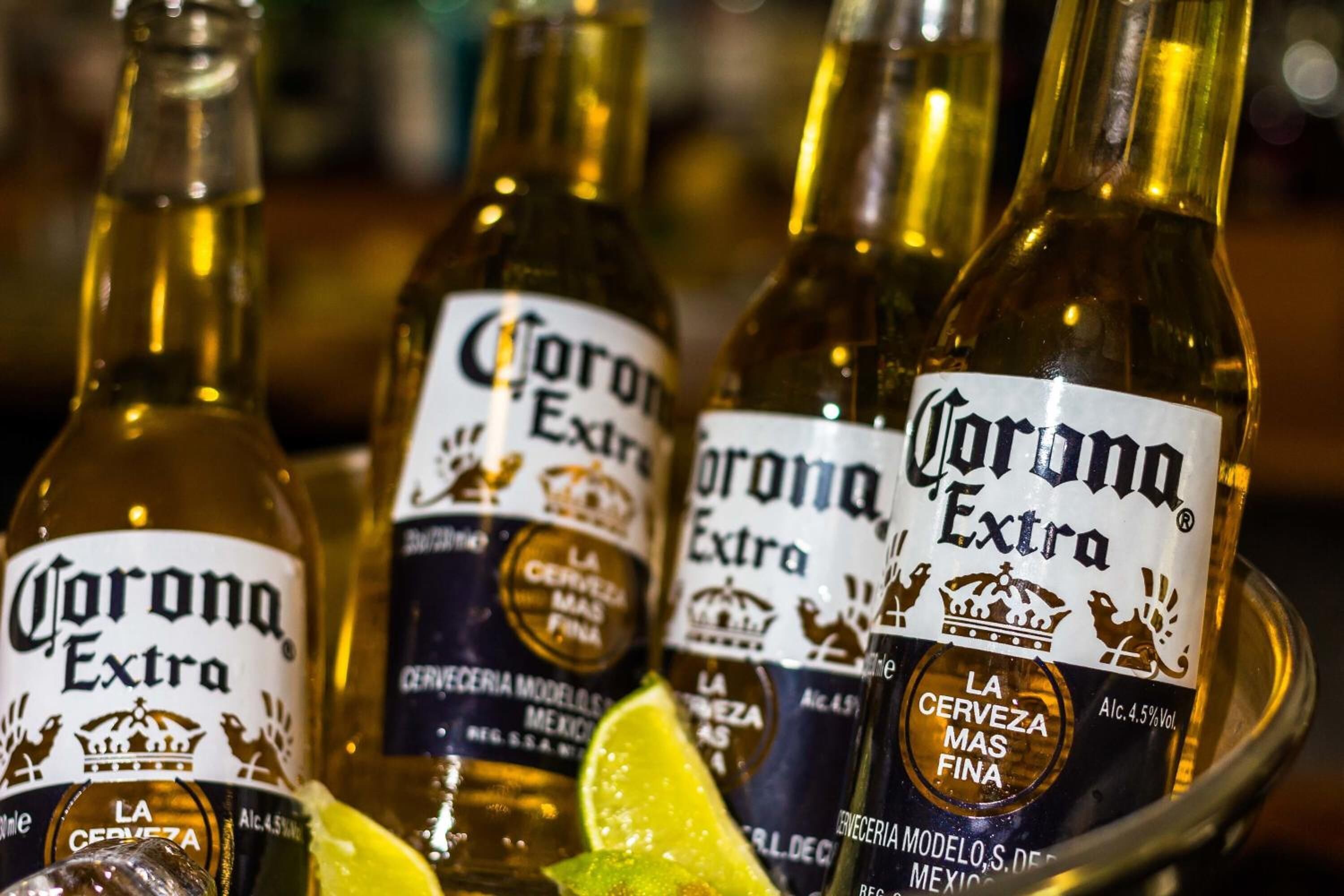 Useita pulloja Corona Extra -olutta, limenviipale ja lasi.