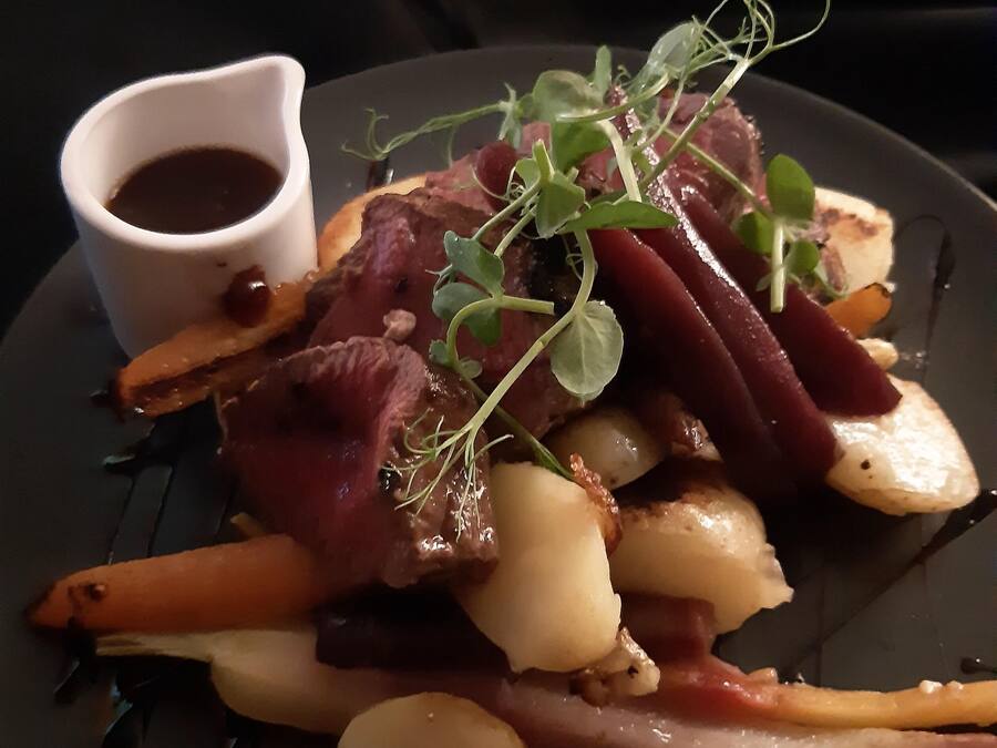 Um prato de comida com um pequeno recipiente de molho.