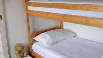 Cozy space with a bunk bed arrangement and a wicker basket for storage.
