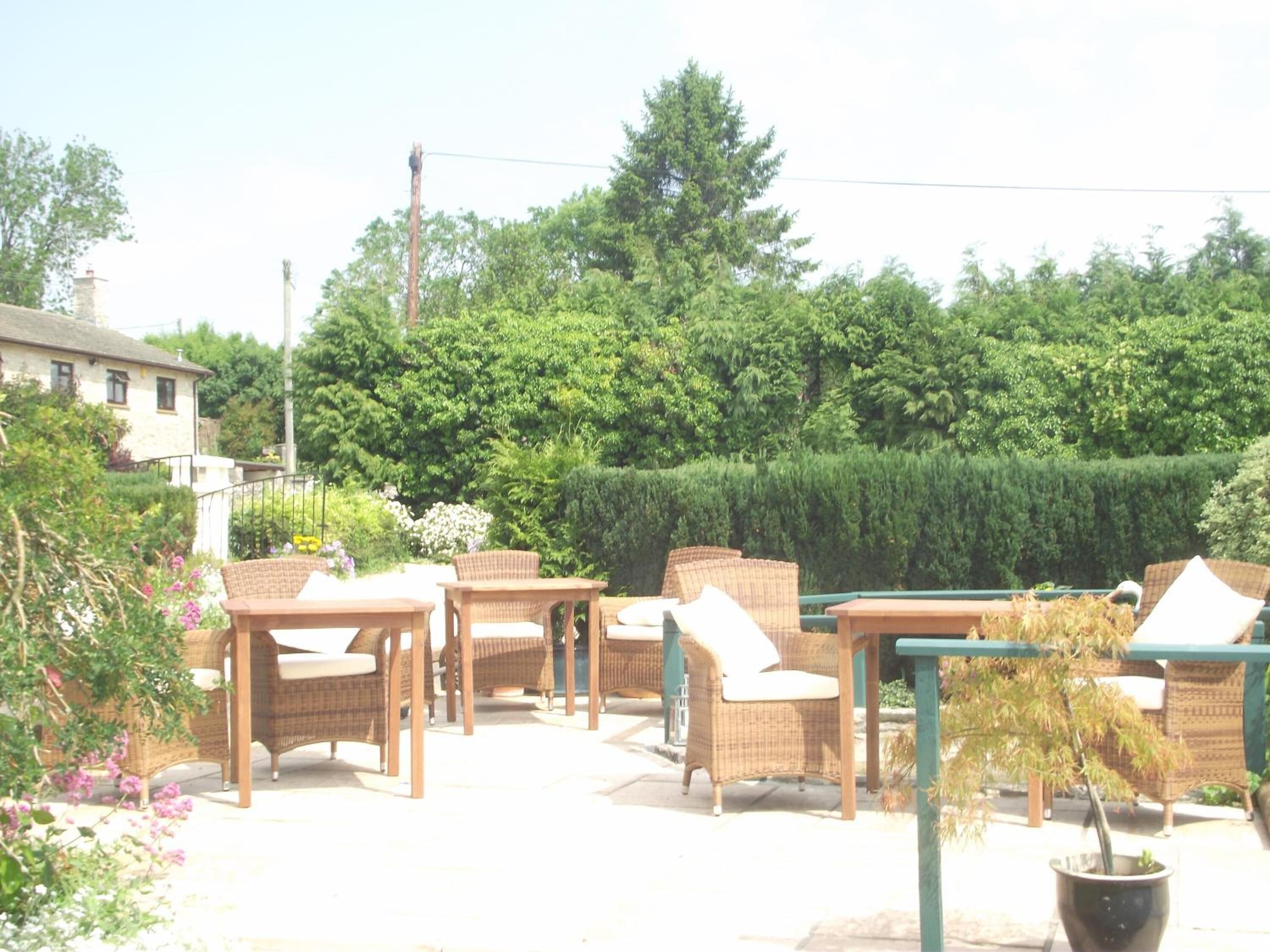An outdoor seating area with wicker furniture and a potted plant.