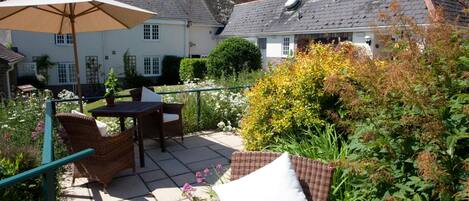 A patio with wicker furniture, a table, and an umbrella.