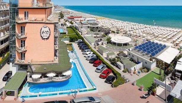A hotel with a swimming pool, beach view, and a parking area. - Hotel Negresco (Cervia)