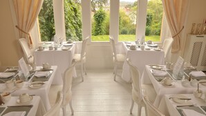 A dining area with white tables and chairs, set for a meal. - Farnley Tower Guesthouse (Durham)