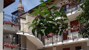 Un edificio de varios pisos con balcones decorados con flores rosadas.