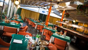 Un restaurante con manteles verdes, sillas naranjas y una zona de bufé.