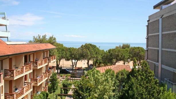 Un hotel con varios balcones con vistas a una playa y al mar.