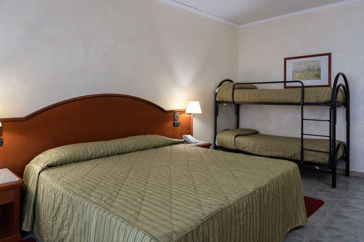 A hotel room with a single bed and a bunk bed.