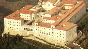 A large, historic building with multiple wings and a central courtyard, surrounded by terraced vineyards. - Edra Palace (Cassino)