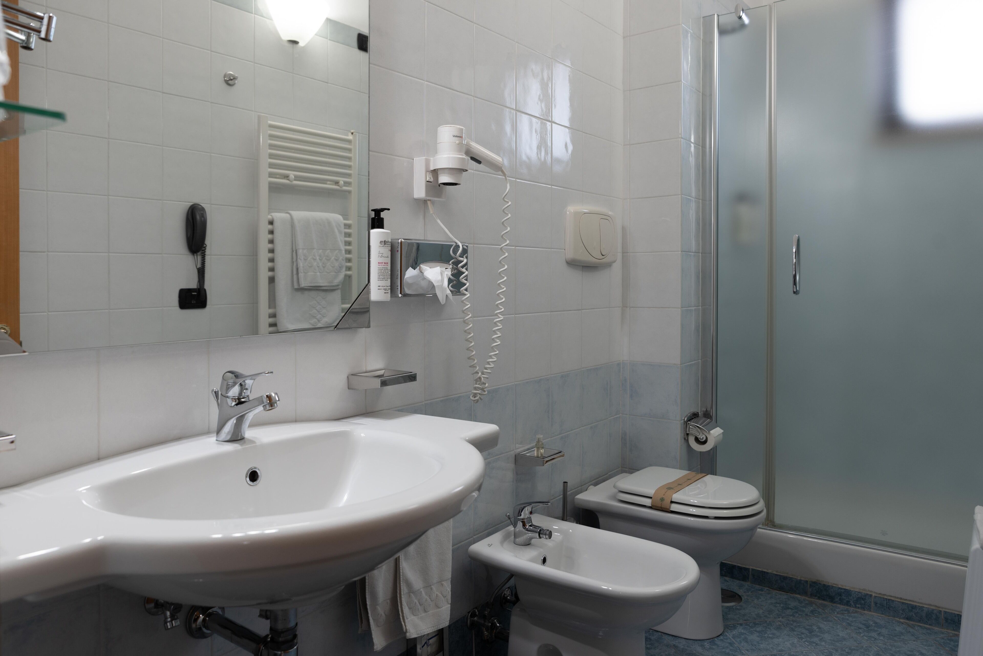A bathroom with a large sink, a toilet, and a shower.