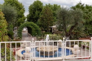 A garden with a fountain, surrounded by trees and a pathway. - Edra Palace (Cassino)