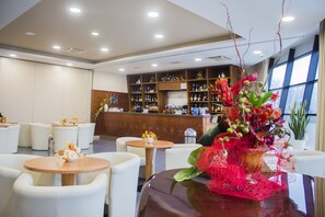A hotel lobby with round tables, white chairs, a reception desk, and a large window. - Edra Palace (Cassino)