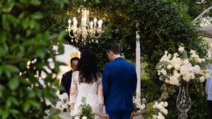 A wedding ceremony with a couple standing under a chandelier, surrounded by greenery and white flowers. - Edra Palace (Cassino)
