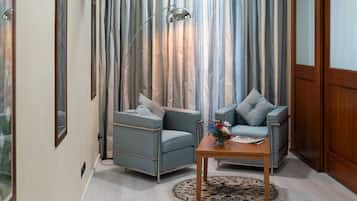 A living room with two grey armchairs, a wooden coffee table, and a floor lamp.