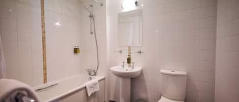 Une salle de bain moderne avec une baignoire, un lavabo sur colonne et des toilettes.