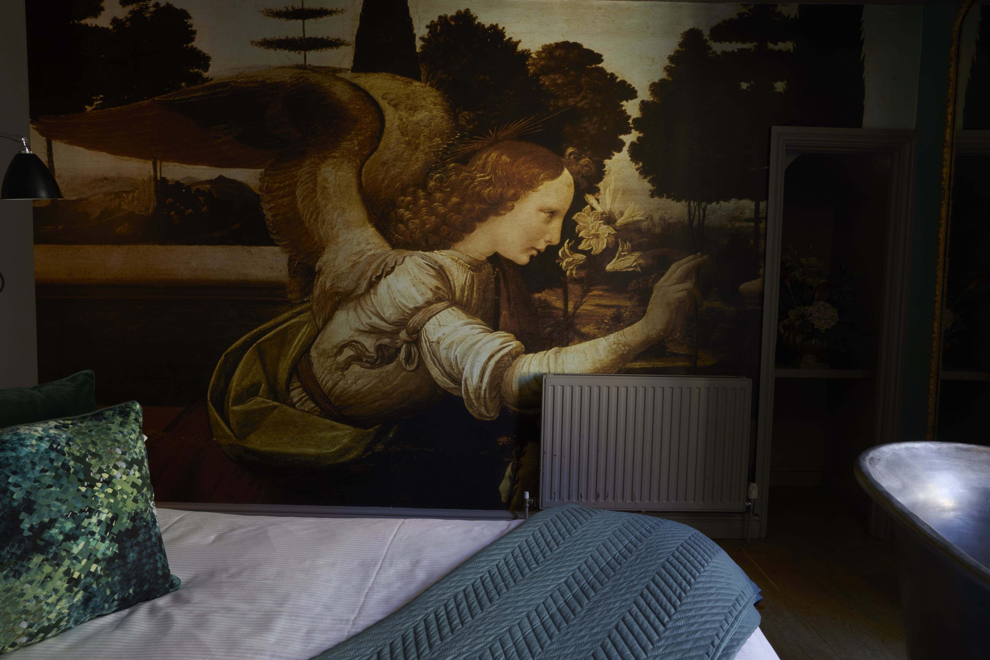 A bedroom with a bed, a radiator, and a wall mural.