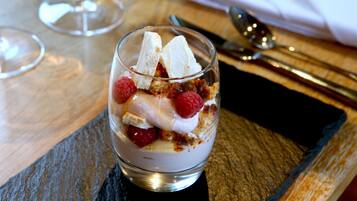 Un dessert servi dans un verre, présenté sur un plateau en ardoise.