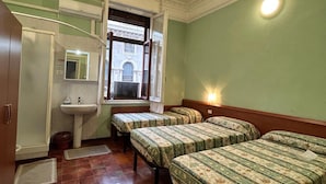 A room with two beds, a sink, and a window with a view of a building. - Hotel Barone (Genoa)
