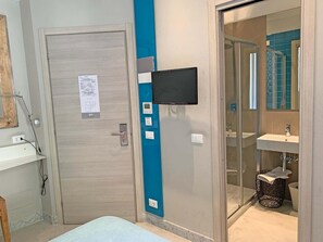 A bathroom with a shower, a sink, and a television mounted on the wall. - Ca' D'andrean (Riomaggiore)