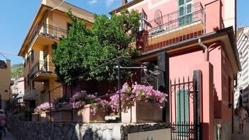Un hotel con ingresso in muratura, balconi dotati di ringhiere e fioriere.