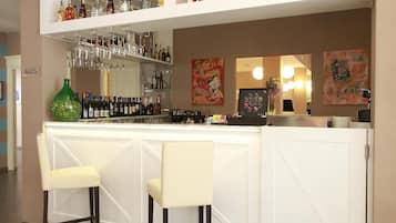 A bar area with two bar stools, shelves of liquor bottles, and a cash register.