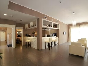 A modern kitchen with a bar area, seating, and a dining area with a view. - Margherita (Monterosso al Mare)