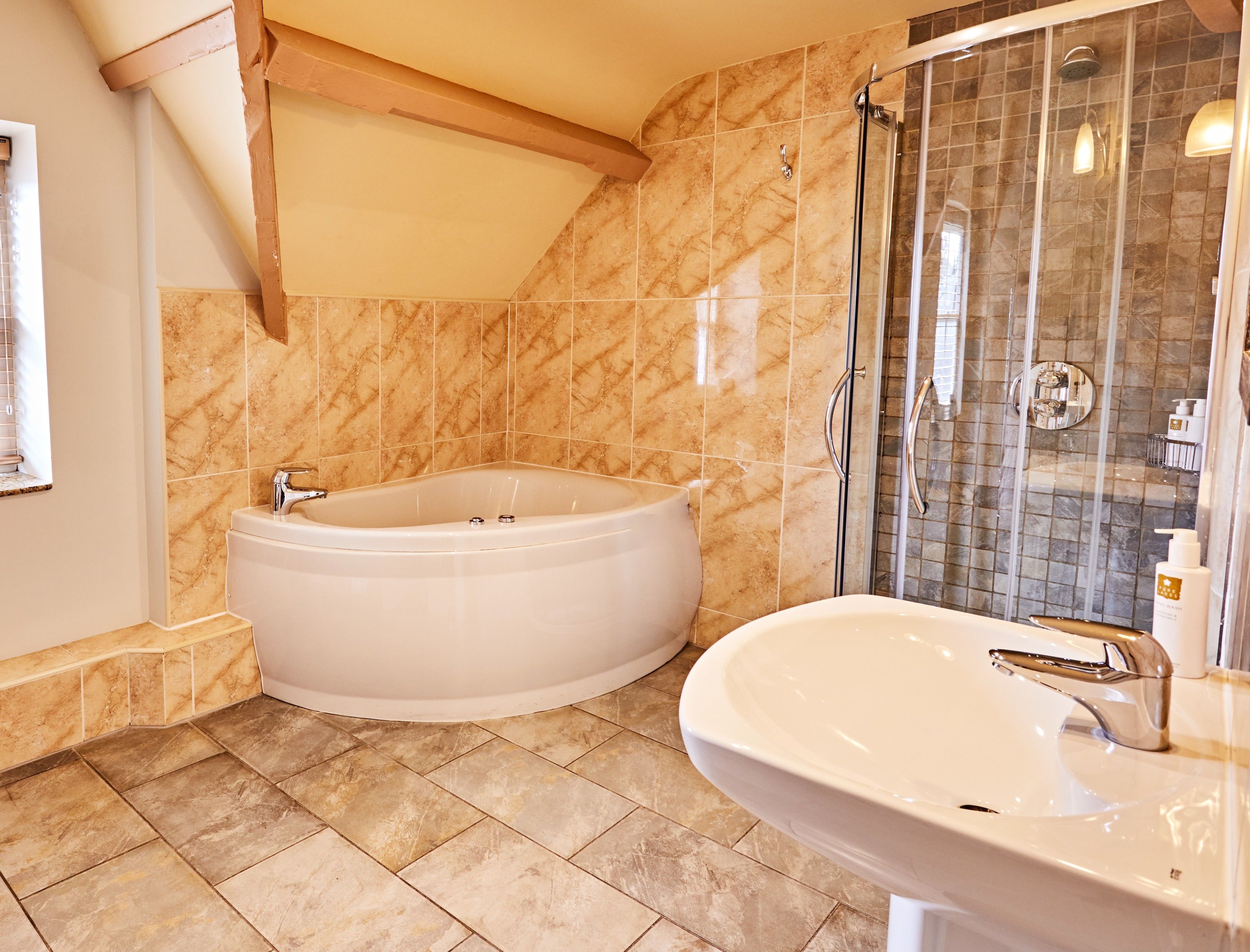 A bathroom with a bathtub, a shower, and a sink.